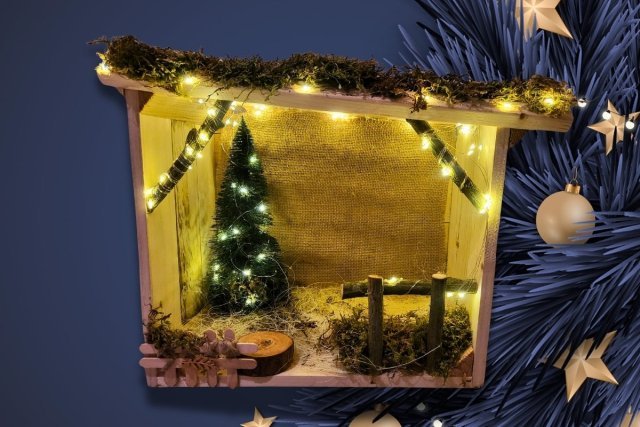 Crèche artisanale bois illuminée avec guirlande lumineuse, sapin miniature et décor naturel pour une ambiance chaleureuse et festive de Noël